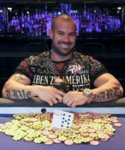 Un tatuatissimo Erik Cajelais mostra felice il braccialetto appena vinto