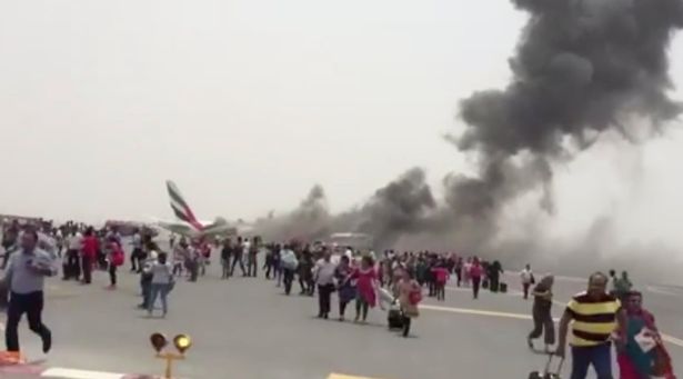Passeggeri in fuga dall'aeroplano in fiamme