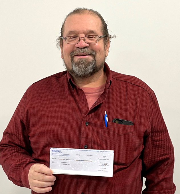 Alex McLeish vincitore del Gratta e Vinci con l'assegno in mano da 650miila dollari (photo courtesy of Massachusetts State Lottery)